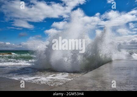 Dramatic view of sea waves crashing against the concrete pier. Power of nature Stock Photo