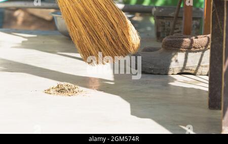 Concept of cleaning with broom - a broom and some garbage Stock Photo