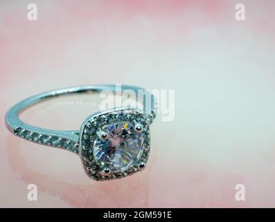 close-up photo silver diamond wedding ring on pink marble Stock Photo
