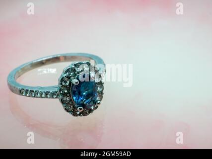 ring with precious stone, sapphire gem set. pink marble background Stock Photo
