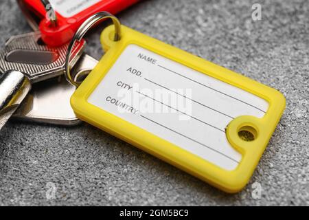 Key with yellow plastic tag on grunge background, closeup Stock Photo