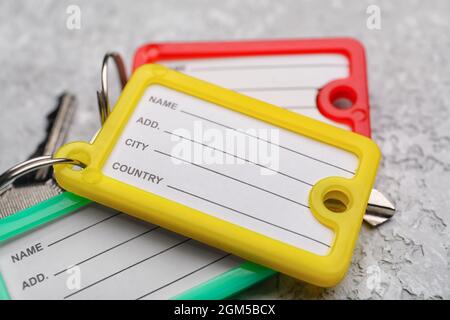 Different plastic key tags on grunge background, closeup Stock Photo