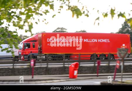 A Royal Mail truck drives down the M27 motorway near Southampton , a side panning view showing deliveries up to 27 million homes logo. Stock Photo