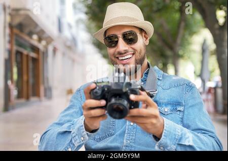 Handsome tourist checking photos in digital camera. High quality photo. Stock Photo