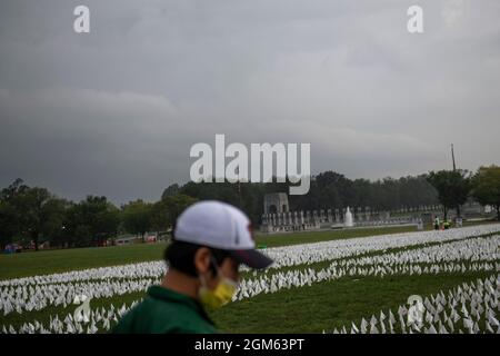 A man works at installing some of the 660,000 white flags, representing the number of US lives lost to Covid-19, on the National Mall in Washington, DC, Thursday, September 16, 2021. The project, by artist Suzanne Brennan Firstenberg, titled âIn America: Rememberâ, will be on display September 17, 2021 through October 3, 2021. Credit: Rod Lamkey/CNP Stock Photo