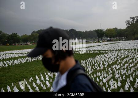 A man works at installing some of the 660,000 white flags, representing the number of US lives lost to Covid-19, on the National Mall in Washington, DC, Thursday, September 16, 2021. The project, by artist Suzanne Brennan Firstenberg, titled âIn America: Rememberâ, will be on display September 17, 2021 through October 3, 2021. Credit: Rod Lamkey/CNP Stock Photo