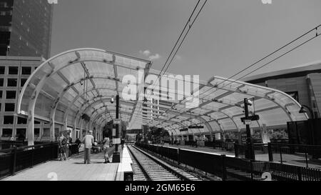 Charlotte, North Carolina, USA - August 24, 2021: Commuters wait on platform for light rail train to arrive. Stock Photo