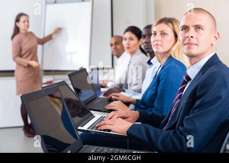 Side view of a group of businessmen undergoing training under the ...