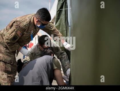 Two Soldiers assigned to the 1st Battalion, 6th Field Artillery Regiment, 41st Field Artillery Brigade assist in repairing a privacy wall during Operation Allies Refuge at Ramstein Air Base, Germany, Sept. 10, 2021. Ramstein Air Base is a transit center that provides a safe place for the evacuees to complete their paperwork while security and background checks are conducted before they continue on to their final destination. (U.S. Army photo by Staff Sgt. Thomas Mort) Stock Photo