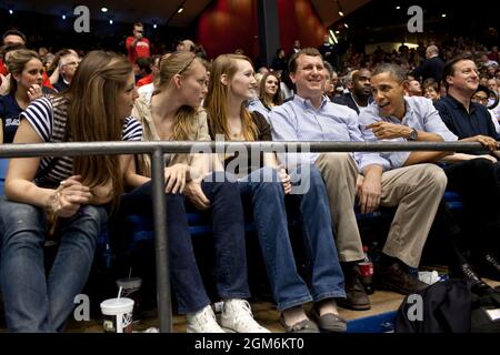 President Barack Obama talks with students during game one of the NCAA Men's Basketball Tournament “First Four” at the University of Dayton Arena in Dayton, Ohio, March 13, 2012. The President watched Mississippi Valley State take on Western Kentucky with Prime Minister David Cameron of the United Kingdom, right, and Trip Director Marvin Nicholson, center. (Official White House Photo by Pete Souza) This official White House photograph is being made available only for publication by news organizations and/or for personal use printing by the subject(s) of the photograph. The photograph may not b Stock Photo