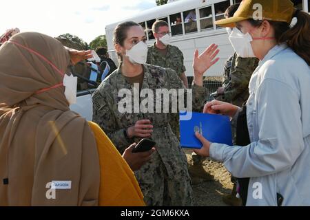 U.S. Navy Lt. Cmdr. Nikki Pritchard, (center) assigned to the Marine Corps Air Ground Combat Center, 29 Palms, San Bernardino, California, and Public Health Lead for Task Force Liberty, interacts with staff members preparing to open the new medical station Liberty Village, Joint Base McGuire-Dix-Lakehurst, New Jersey, Sept. 11, 2021.  The Department of Defense, through U.S. Northern Command, and in support of the Department of Homeland Security, is providing transportation, temporary housing, medical screening, and general support for at least 50,000 Afghan evacuees at suitable facilities, in Stock Photo