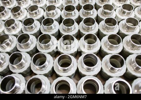 many metal pipe couplings in a pipe factory Stock Photo