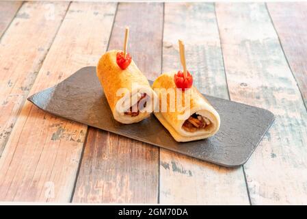 Sandwich roll with grilled sliced bread stuffed with bacon and cheese with tomato on wooden table Stock Photo
