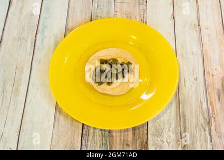 Simple taco of nopales with melted cheese and corn tortilla on a yellow plate. Stock Photo