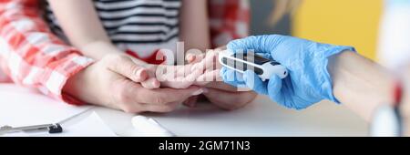 Doctor measuring blood glucose level of little girl with glucometer closeup Stock Photo