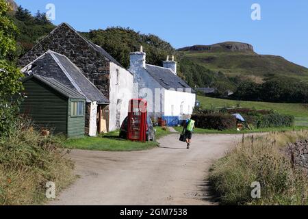 Isle of Canna, quiet main road on the island in the Inner Hebrides of Scotland. The post office is the green shed behind the phone box.