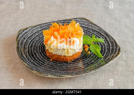 wonderful individual carrot cake with two layers, one ice cream and one sponge cake and the top of carrot and caramel chips Stock Photo