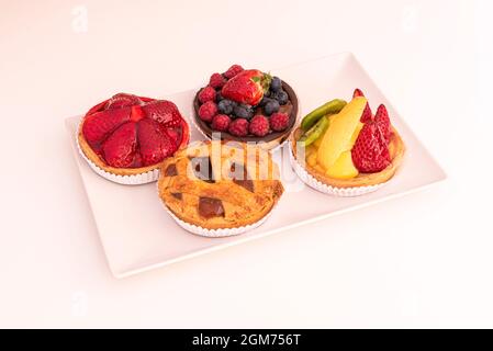Tartlets with assorted fruits, strawberries, berries, kiwi and mango. Apple pie. Stock Photo