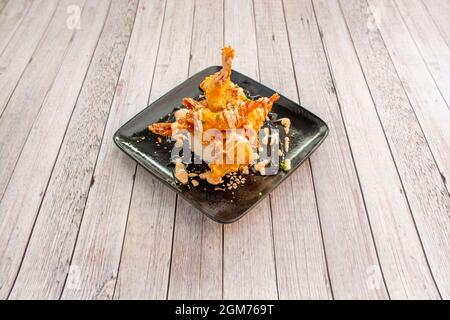 Prawn tempura cooked in a Chinese restaurant with black plates and light tables Stock Photo