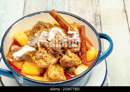 Delicious Thai sweet massaman beef curry in white and blue enameled metal bowl Stock Photo