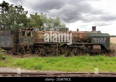 Derelict train, vintage steam engine, or steam locomotive, rusting in a field, Epping Essex UK Stock Photo