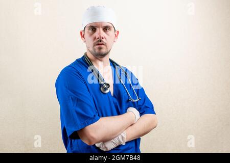 Doctor in mask and blue uniform, shows strength. Stock Photo