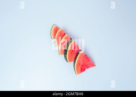 Seedless triangular watermelon portions on blue table Stock Photo