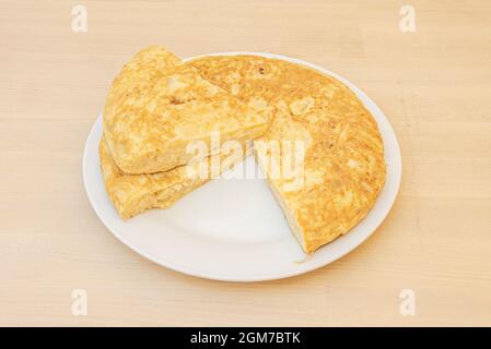 Spanish omelette with potatoes and eggs with a separate portion and placed on top so that the interior is well set. Stock Photo