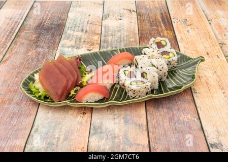 Assorted sushi platter with bluefin tuna nigiri, fresh bluefin tuna sashimi, uramaki california roll with avocado and tuna with sesame and poppy seeds Stock Photo