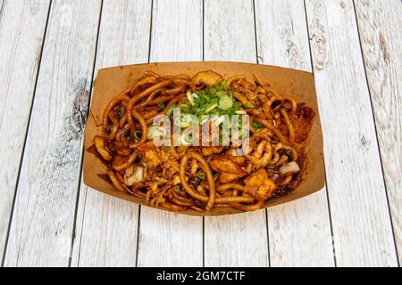 Asian recipe for udon noodles with fried chicken and vegetables sautéed with soy sauce and chives Stock Photo