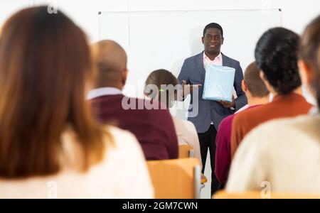African american coach businessman giving talk at modern office conference to multiethnic team Stock Photo