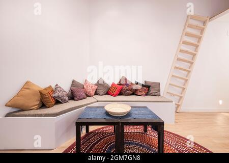 Living room decorated in Moroccan style with a long-cushioned sofa and many cushions Stock Photo