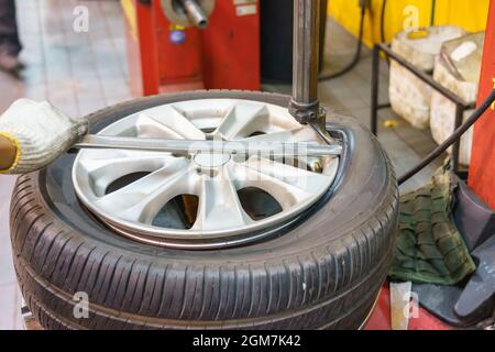 Close-up of Mechanic changing car tire in workshop Stock Photo
