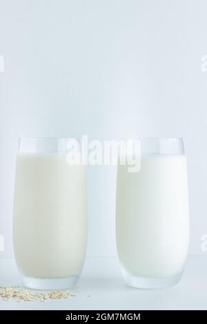 Close up of one glass of oat and cow milk on white background with copy space; sustainable and eco-friendly; comparison Stock Photo