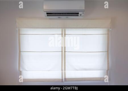 White air conditioner hanging on white wall. Air cool Stock Photo - Alamy