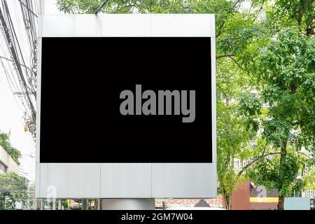 Billboard with empty screen for outdoor advertising, against blue cloudy sky Stock Photo