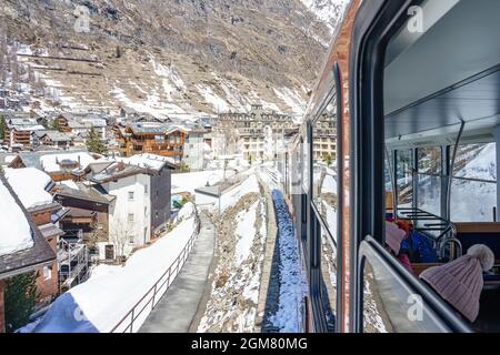 ZERMATT, SWITZERLAND - APRIL 13. 2018: Red train climbing up to Gornergrat station on Zermatt, Switzerland. The Gornergrat rack railway is the highest Stock Photo