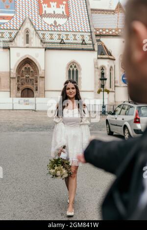 Selective focus photo of groom holding out his hand as bride is walking toward him. Stock Photo