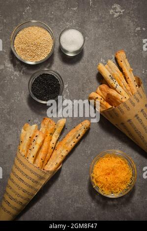 Salted Cheese Straws and Sesame Seeds In A Paper Cone Stock Photo