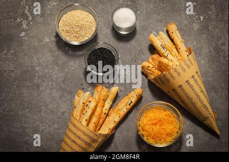Salted Cheese Straws and Sesame Seeds In A Paper Cone Stock Photo