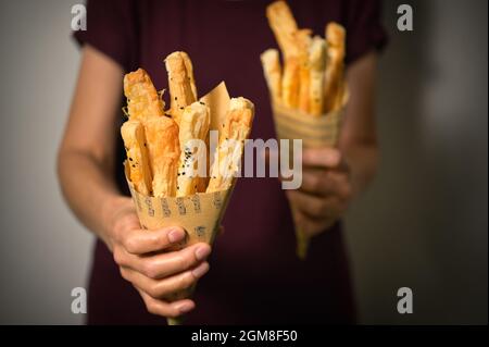 Salted Cheese Straws and Sesame Seeds In A Paper Cone Stock Photo