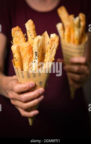 Salted Cheese Straws and Sesame Seeds In A Paper Cone Stock Photo