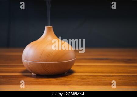 Essential aroma oil diffuser on the wooden table. Stock Photo