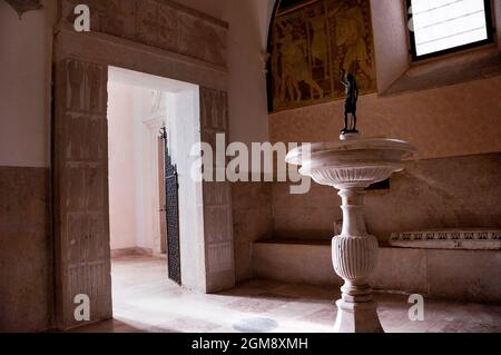 Carved stone doorway and landing with a bench and fountain in Montecassino Abbey in Italy. Stock Photo