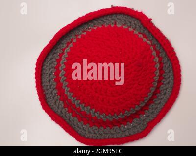 Picture of red color with grey stripes crochet hat. Shoot on isolated white background Stock Photo
