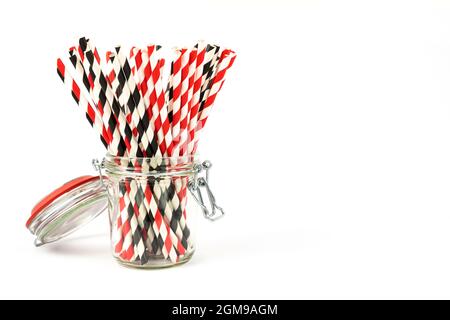Festive paper straws for drinks in a glass jar on a white background with a place for the text. Stock Photo