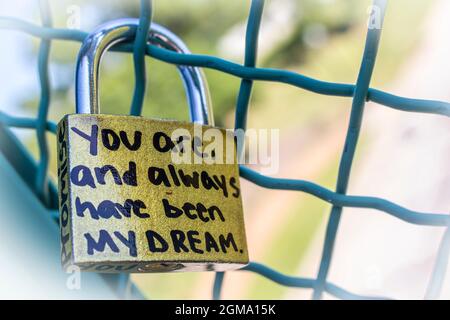 Gold love lock on frence that says Promise and You are and always have been my dream with bokeh background Stock Photo