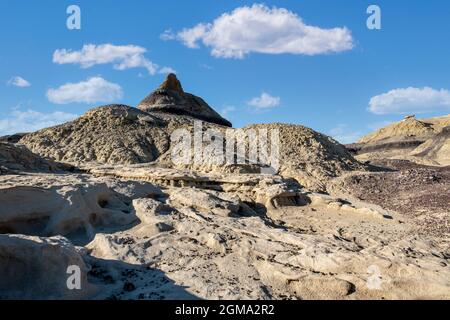 Hiking in the badlands reveals surprises like this stark black pyramidal shaped hill top Stock Photo