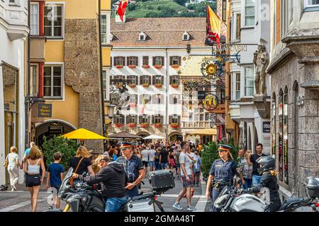 Strolling tourists visit the Golden Roof, Goldenes Dachl, and the picturesque decorated houses on Herzog-Friedrich-Strasse. Innsbruck, Tyrol, Austria Stock Photo