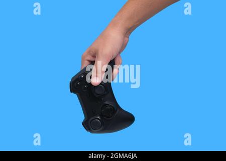 Gamepad in man hand on blue background, game joystick, computer games and entertainment Stock Photo